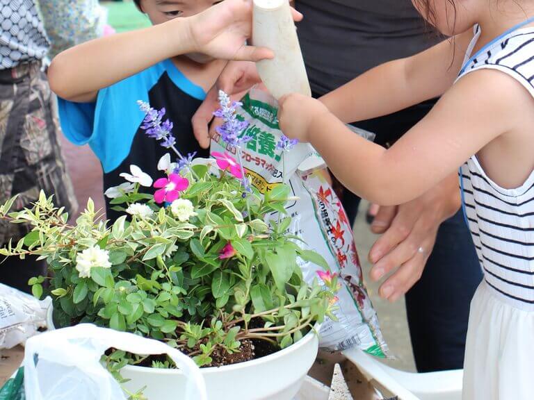 写真：孫とお庭でお花を一緒に触れ合う様子